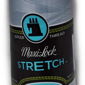 Peut inclure: Une bobine de fil à coudre sergé Maxi-Lock Stretch bleu clair. L'étiquette indique "Maxi-Lock Stretch" et "Doux, comme du fil, Nylon texturé".