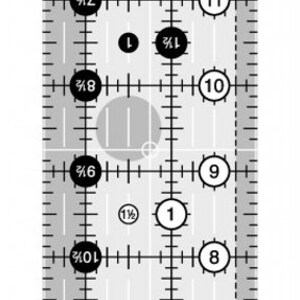 Op de afbeelding: Een zwart-witte quiltliniaal met markeringen voor 1/8 inch, 1/4 inch, 1/2 inch en 3/4 inch. De liniaal heeft ook markeringen voor 1/2 inch, 1 inch en 1 1/2 inch. De liniaal heeft een hoek van 45 graden en een hoek van 60 graden. De liniaal is ontworpen door Rachel Cross.