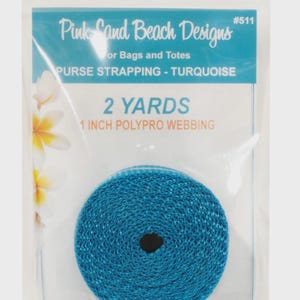 May include: A roll of turquoise 1 inch wide polypro webbing for bags and totes, measuring 2 yards in length. The packaging is labeled Pink Sand Beach Designs #511, Purse Strapping - Turquoise, 2 Yards, 1 Inch Polypro Webbing with floral art.