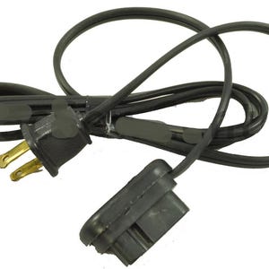 May include: A black power cable with a two-pin plug and a female connector. The cable is looped and has a rectangular connector on one end and a standard UK plug on the other.