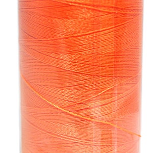Puede incluir: Una bobina de hilo naranja brillante en un recipiente de plástico transparente con una tapa negra.