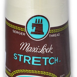 Puede incluir: Una bobina de hilo Maxi-Lock Stretch Serger de color crema. La bobina está etiquetada con "Maxi-Lock Stretch" y "Soft, Like Yarn Textured Nylon".