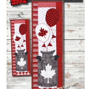 Peut inclure: Un modèle de courtepointe pour une suspension murale en forme de bidon de lait pour la fête du drapeau. Le motif représente un bidon de lait avec un drapeau canadien, des ballons et un fond à carreaux rouge et blanc. Le motif mesure 15,2 cm sur 45,7 cm et est classé "Facile". Le motif est de Patch Abilities, Inc. et indique "Terminer en une journée !"