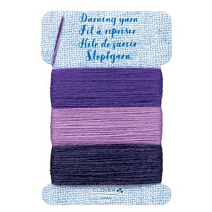 May include: A spool of darning yarn in shades of purple, with a needle attached to the top. The label reads "Darning yarn, Fil à repriser, Hilo de zurcir, Stoppgarn." The brand name "Clover" is visible at the bottom.