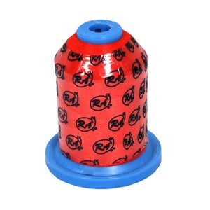 Puede incluir: Una bobina de hilo naranja brillante con una base de plástico azul. La bobina está envuelta en plástico transparente y tiene un patrón repetido de logotipos negros "RA".