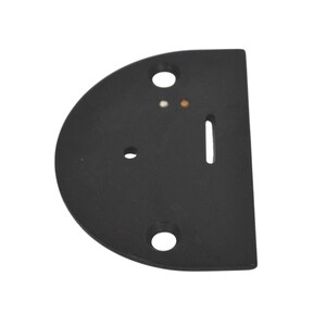 以下が含まれることがあります： 黒色の半円形のミシン針板。3つの穴と針用のスロットがあります。このプレートは、ミシンで使用するために設計された、しっかりとしたマットな素材で作られています。