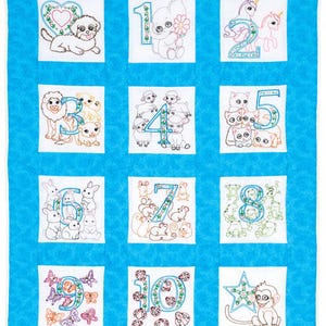 Puede incluir: Una colcha para bebé azul y blanca con números bordados del 1 al 10. Cada número está rodeado de un animal diferente, incluyendo un cachorro, un elefante, un unicornio, un león, un cordero, un gato, un conejito, un ratón, una rana, una mariposa, una mariquita y un mono.