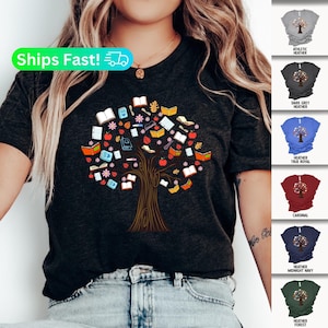 May include: A dark heather grey t-shirt with a graphic of a tree made of books, pencils, and other school supplies. The t-shirt is available in 10 colors: Athletic Heather, Dark Grey Heather, Heather True Royal, Cardinal, Heather Midnight Navy, and Heather Forest.