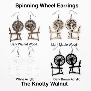May include: Four pairs of spinning wheel earrings in different colors and materials. The earrings are made of dark walnut wood, light maple wood, white acrylic, and dark brown acrylic. The earrings are all the same design, featuring a spinning wheel with a stand.