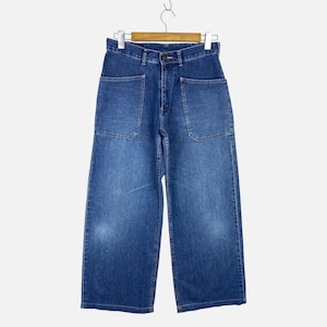 May include: A pair of medium-wash blue denim jeans featuring a high-waisted fit, a wide-leg silhouette, and two large, square-shaped patch pockets on the front. The jeans include a standard button closure, a zipper fly, and belt loops at the waist.