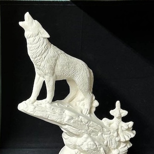 Peut inclure: Sculpture en céramique blanche représentant un loup hurlant sur un socle rocheux avec un petit arbre. Le loup est représenté la tête levée et la gueule ouverte. La sculpture est non peinte et a une surface texturée.