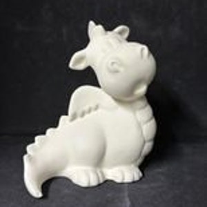 May include: White ceramic figurine of a cartoon dragon with a wide open mouth, sitting on its haunches with its wings spread out.
