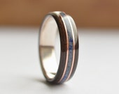 Handmade bog eucalyptus wood ring with crushed lapis lazuli, glow powder and double copper inlays on sterling silver core. Glows in the dark