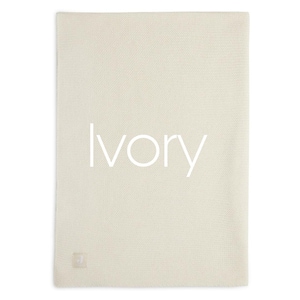 Puede incluir: Manta rectangular de color marfil con una superficie texturizada. La palabra "Ivory" est&aacute; impresa en blanco en el centro de la manta. Una peque&ntilde;a etiqueta cuadrada est&aacute; en la esquina inferior.