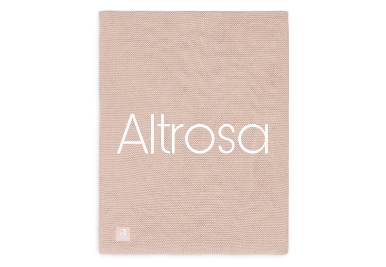 Puede incluir: Una manta de punto color rosa p&aacute;lido con la palabra "Altrosa" en letras blancas en el centro. La manta tiene un aspecto texturizado y una peque&ntilde;a etiqueta blanca en la esquina inferior izquierda.