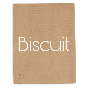 Puede incluir: Una manta de punto de color beige con la palabra "Biscuit" en blanco, centrada en la parte delantera. La manta tiene un aspecto texturizado y una peque&ntilde;a etiqueta en la esquina inferior izquierda.