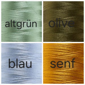 Puede incluir: Cuatro carretes de hilo en diferentes colores: verde claro con el texto "altgr&uuml;n", verde oliva con el texto "olive", azul claro con el texto "blau" y amarillo mostaza con el texto "senf". El hilo est&aacute; bien enrollado.