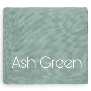 Puede incluir: Un textil plegado de color verde ceniza apagado, con una textura tejida visible. Las palabras "Ash Green" est&aacute;n impresas en blanco en el centro. El textil es de forma cuadrada.