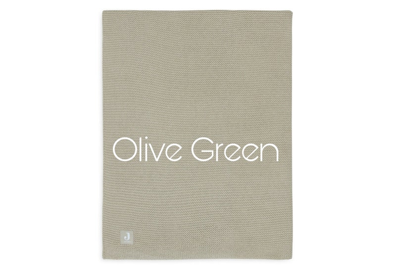 Puede incluir: Manta de punto verde oliva. La manta es de color verde oliva liso con un patr&oacute;n de punto texturizado. Las palabras "Olive Green" est&aacute;n impresas en blanco en la manta. Una peque&ntilde;a etiqueta blanca est&aacute; en la esquina inferior.
