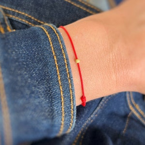 Pulsera sencilla de hilo rojo con cuentas bañadas en oro de 18 quilates: un regalo minimalista para el día a día, inspirado en tradiciones significativas.