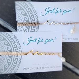 May include: Two handmade bracelets with a wave charm and a pearl bead. The bracelets are on white cards with the text "Just for you!" and the website address "www.justseedbeads.etsy.com".
