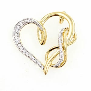 May include: A gold-toned pendant in the shape of a heart, with a section of the heart outlined with small, clear gemstones. The pendant also features a gold-toned infinity symbol intertwined with the heart shape.