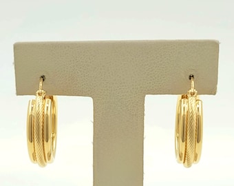 May include: A pair of gold hoop earrings with a textured design. The earrings are on a white display stand.