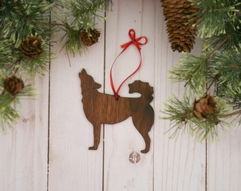 May include: Wooden Christmas ornament shaped like a howling wolf, painted brown, with a red ribbon attached.