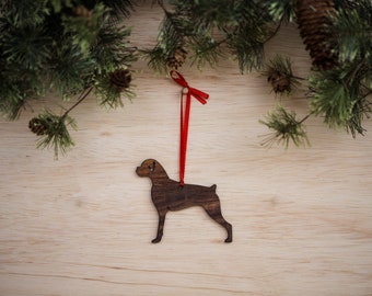 May include: A wooden Christmas ornament shaped like a brown dog with a red ribbon attached.