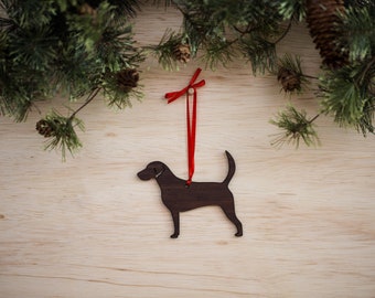 May include: A wooden Christmas ornament shaped like a black dog with a red ribbon attached.