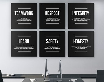 May include: Six black square signs with white text on a white wall. The signs have the words "Teamwork", "Respect", "Integrity", "Learn", "Safety", and "Honesty" with a short description of each value below.