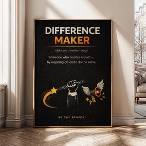 May include: A framed black poster with the words "DIFFERENCE MAKER" in white and orange. The poster includes a definition, a hand holding a chain with a star, and a megaphone with wings. The phrase "BE THE REASON" is at the bottom.