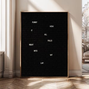 May include: A framed black felt letter board with gold trim. The white letters spell out "Funny it right into my lap. How all falls." The board is displayed in a well-lit room with a neutral colour palette.