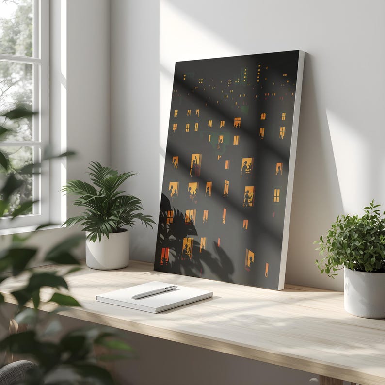 K&ouml;nnte beinhalten: Ein gerahmter Kunstdruck, der eine n&auml;chtliche Stadtlandschaft mit beleuchteten Fenstern zeigt. Das Kunstwerk hat einen dunklen Hintergrund mit zahlreichen rechteckigen Fenstern, die mit warmem, orangefarbenem Licht leuchten. Der Druck steht auf einem Holztisch, neben einem Notizbuch, einem Stift und Topfpflanzen.
