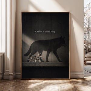May include: A framed vertical wall art print featuring a small puppy walking on a ledge, casting a large shadow of a wolf on the dark wall behind it. The text "Mindset is everything." is printed in white, centered above the wolf shadow.