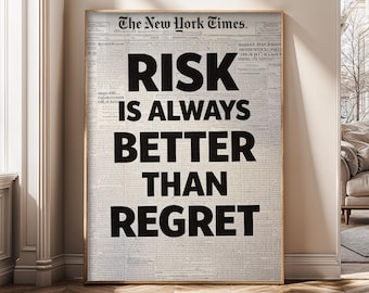 Op de afbeelding: Een ingelijste print met de tekst "RISK IS ALWAYS BETTER THAN REGRET" in vette zwarte letters. De achtergrond is een krantenprint, met "The New York Times" bovenaan.