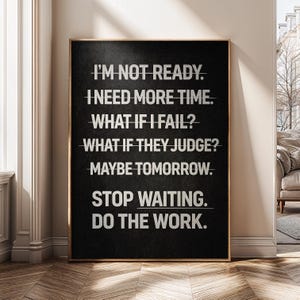 May include: Black framed wall art with white text that reads: "I'M NOT READY. I NEED MORE TIME. WHAT IF I FAIL? WHAT IF THEY JUDGE? MAYBE TOMORROW. STOP WAITING. DO THE WORK." The art is displayed in a room with a wooden floor.