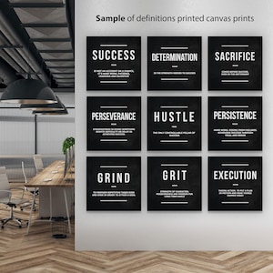 May include: Nine black square canvas prints with white text, each displaying a definition of words like "Success", "Determination", and "Sacrifice". The prints are displayed in a modern office setting.