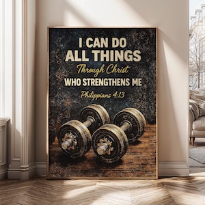 May include: A framed print featuring two dumbbells on a wooden surface. The print has the text "I CAN DO ALL THINGS Through Christ WHO STRENGTHENS ME Philippians 4:13" in white and gold lettering against a dark background.