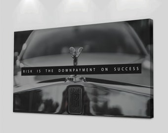 May include: Black and white photo of a luxury car with the Rolls Royce emblem. The hood of the car has the text "RISK IS THE DOWNPAYMENT ON SUCCESS" printed on it.