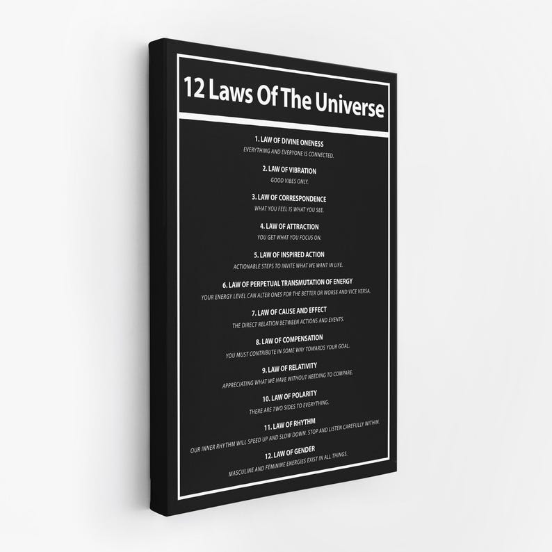 May include: Black framed canvas print featuring the text "12 Laws Of The Universe" in white. The print lists twelve laws with brief descriptions, including the Law of Attraction and the Law of Vibration. The background is black.