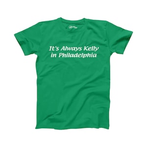 Könnte beinhalten: Ein grünes T-Shirt mit dem Aufdruck "It's Always Kelly in Philadelphia" in weiß.