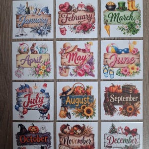May include: A set of twelve square stickers, each featuring a wooden sign with the name of a month and seasonal illustrations. January shows winter items, February hearts, March St. Patrick's themes, April Easter, May flowers, June beach gear, July patriotic items, August sunflowers, September harvest, October Halloween, November Thanksgiving, and December Christmas.