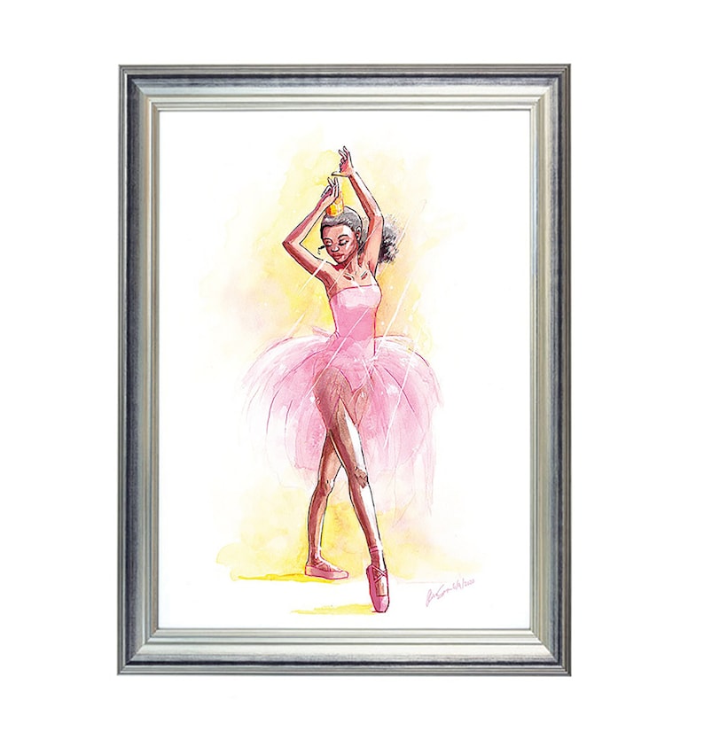May include: Watercolor painting of a ballerina in a pink tutu and pointe shoes, framed in a silver frame. The ballerina is posed with arms raised, wearing a crown. The background is a soft yellow.