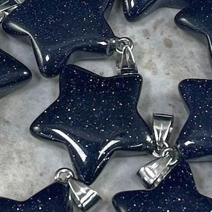 May include: A set of eight star-shaped pendants made of blue sandstone with silver-toned metal bail loops. The pendants are approximately 1 inch in size.