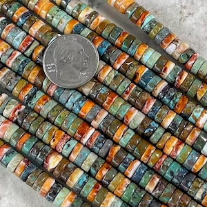 以下が含まれることがあります： マルチカラーのターコイズビーズのストランド。ビーズは丸くて平らで、一列に並んでいます。ビーズは青、緑、茶色のさまざまな色合いです。ビーズの直径は約1.25cmです。