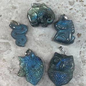 May include: Five labradorite gemstone pendants with silver bail, each carved in the shape of an animal: elephant, unicorn, snake, wolf, and owl.