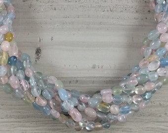 May include: A strand of pastel-coloured gemstone beads. The beads are oval-shaped and have a smooth, polished finish. The colours include light blue, pink, and green.