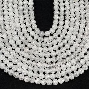 May include: A strand of clear quartz beads with a bubbled or crackled texture. The beads are round and uniform in size.