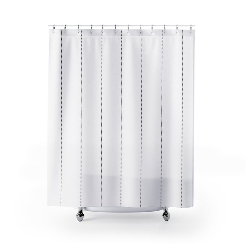 May include: White shower curtain with black dotted lines. The curtain is hanging from a chrome shower rod.